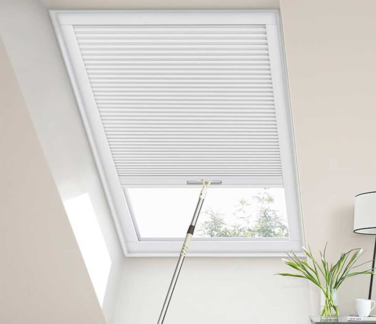 White cellular skylight blind fitted to an angled roof window